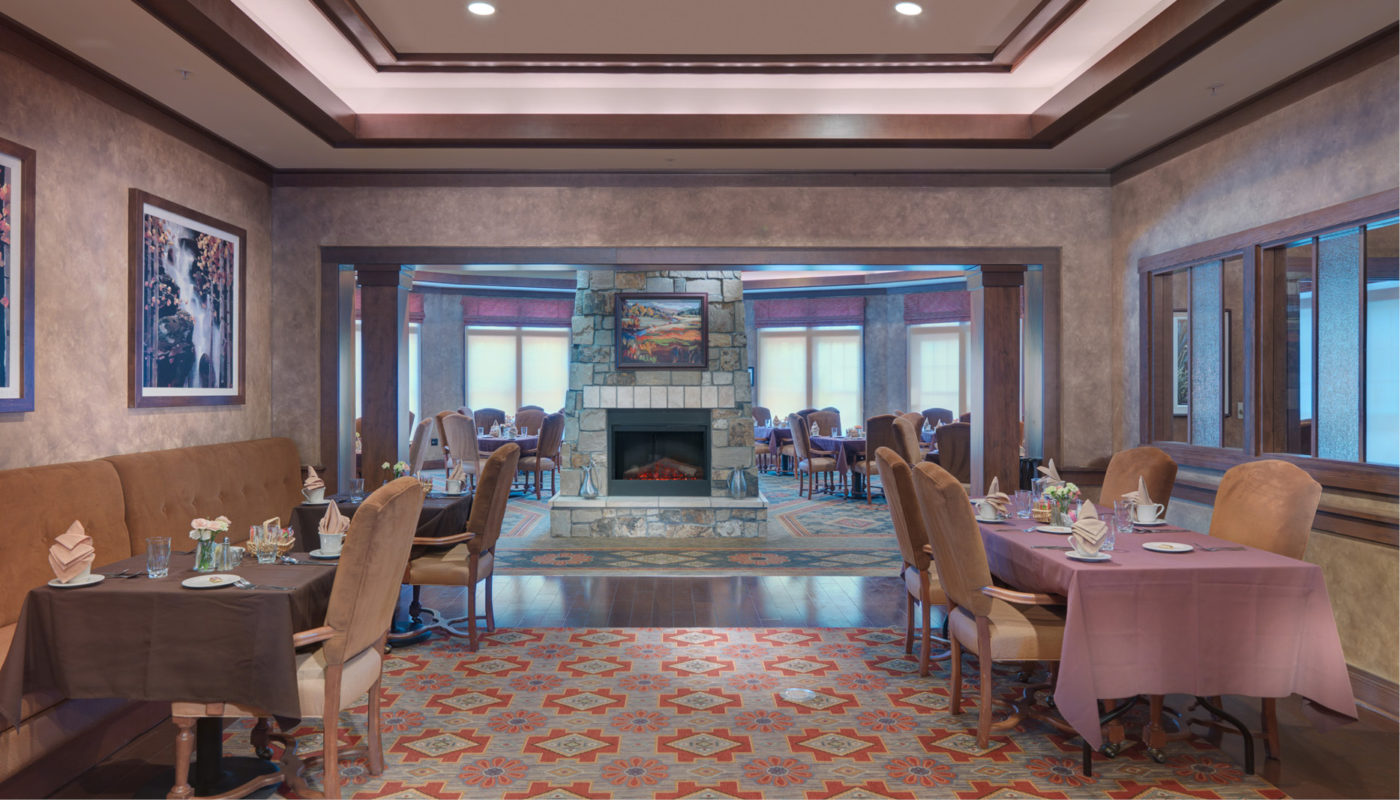 A dining room with a fireplace and couches, ideal for cozy evenings by the fire or enjoying breakfast while overlooking the breathtaking sunrise over the FlatIrons.