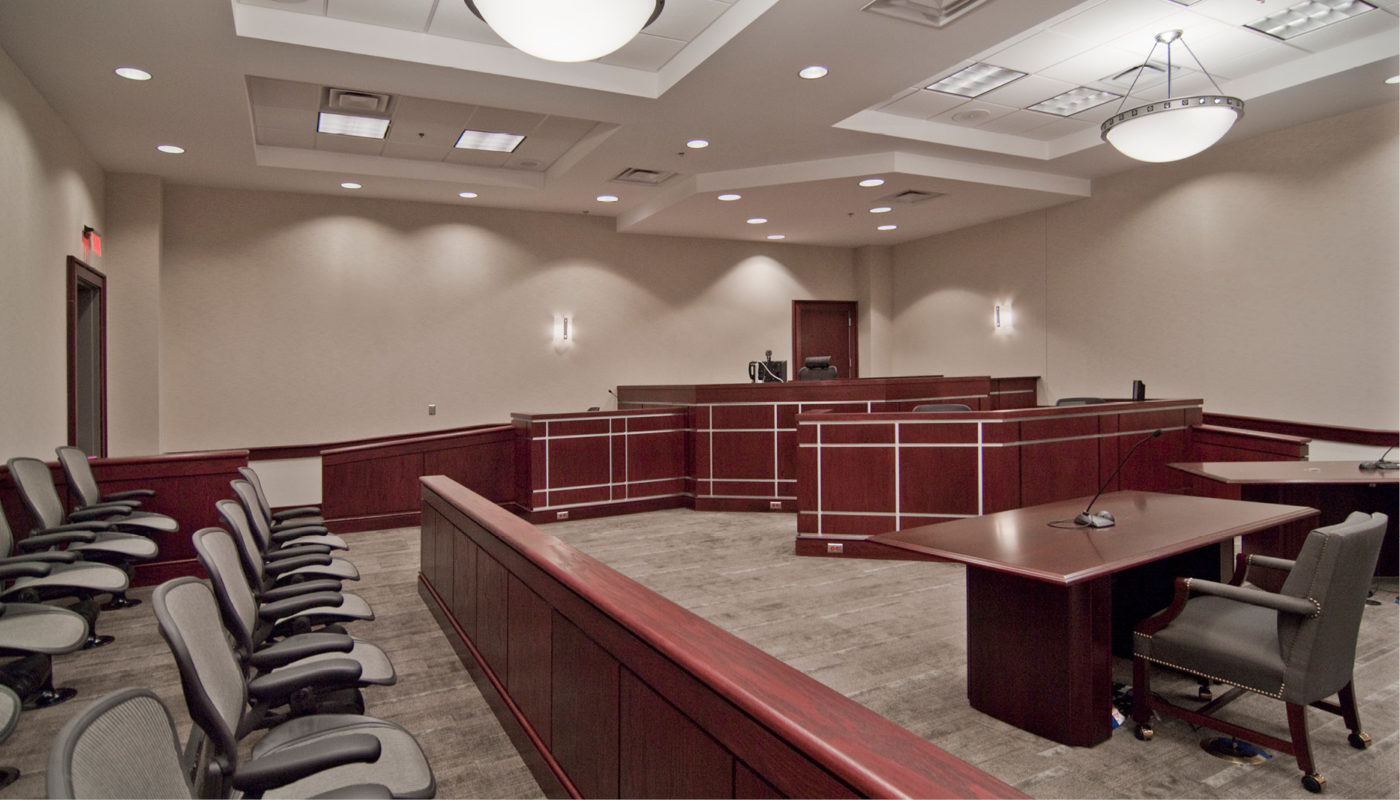 A courtroom with a bench and chairs.