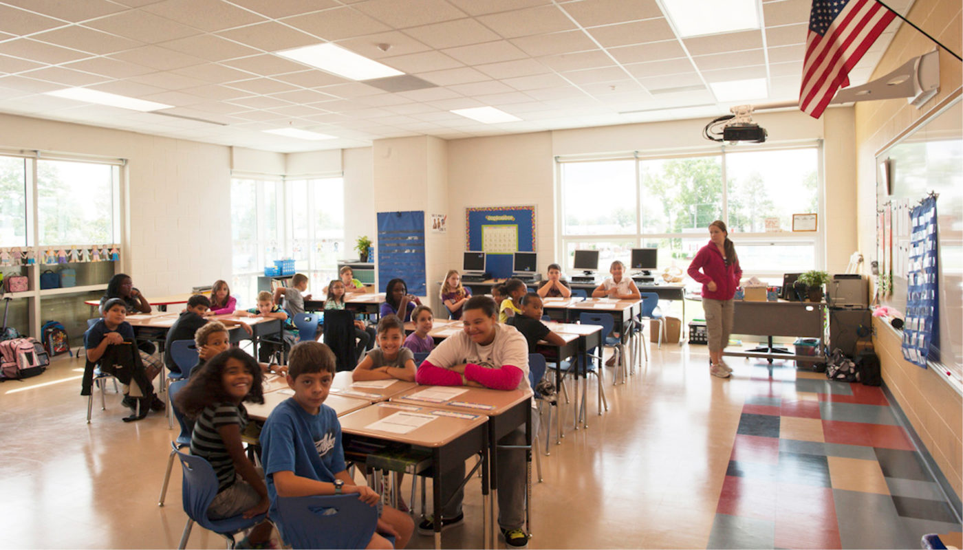 A group of children in a PreK-8 school classroom.