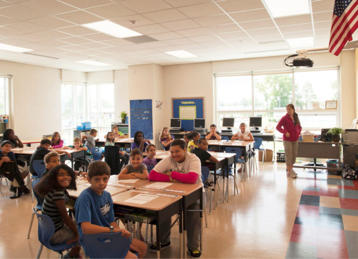 A group of children in a PreK-8 school classroom.
