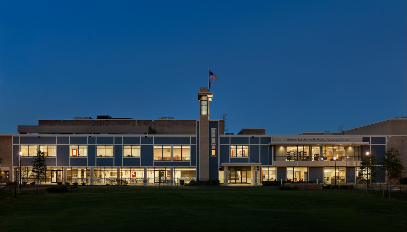 The SEED School of Maryland, a prominent educational institution affiliated with the SEED Foundation, features a stunning building adorned with an illuminated clock at night.