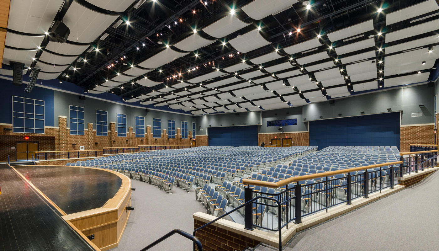 A large auditorium with blue chairs at Colgan High School, part of Prince William County Public Schools
