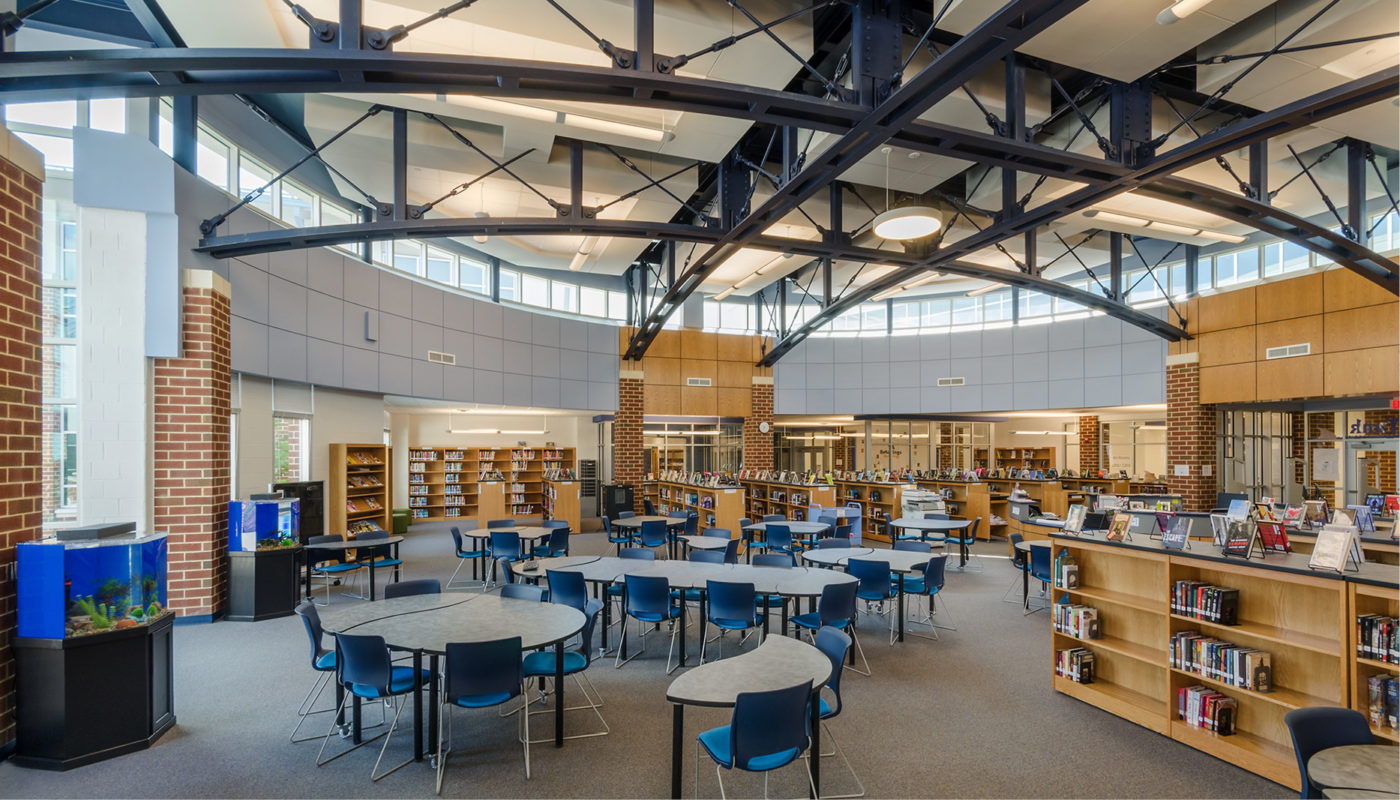 The interior of Prince William County Public Schools library with blue chairs and tables.
