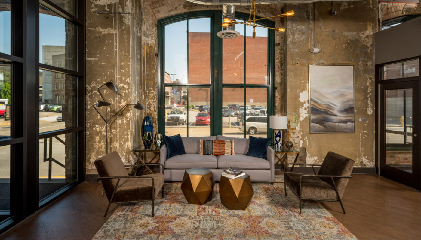 A Boury Lofts living room showcasing an industrial aesthetic with large windows.