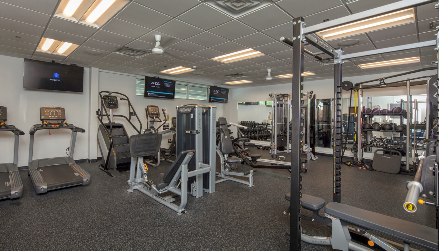 A gym room with tread machines and TVs located at the Central District Police Station.