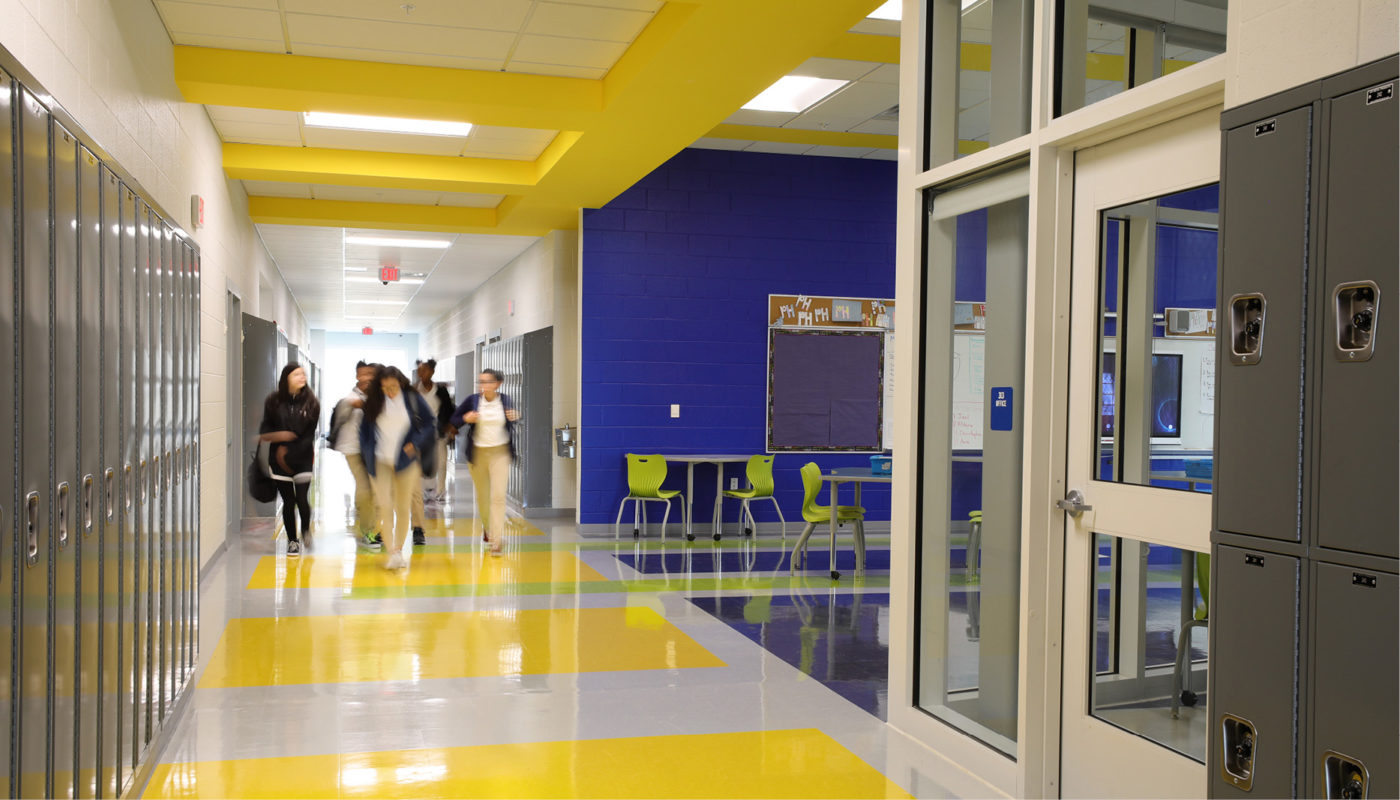 A hallway with yellow and blue walls and lockers at Patrick Henry K-8 School.