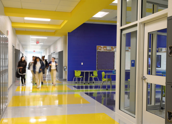 A hallway with yellow and blue walls and lockers at Patrick Henry K-8 School.