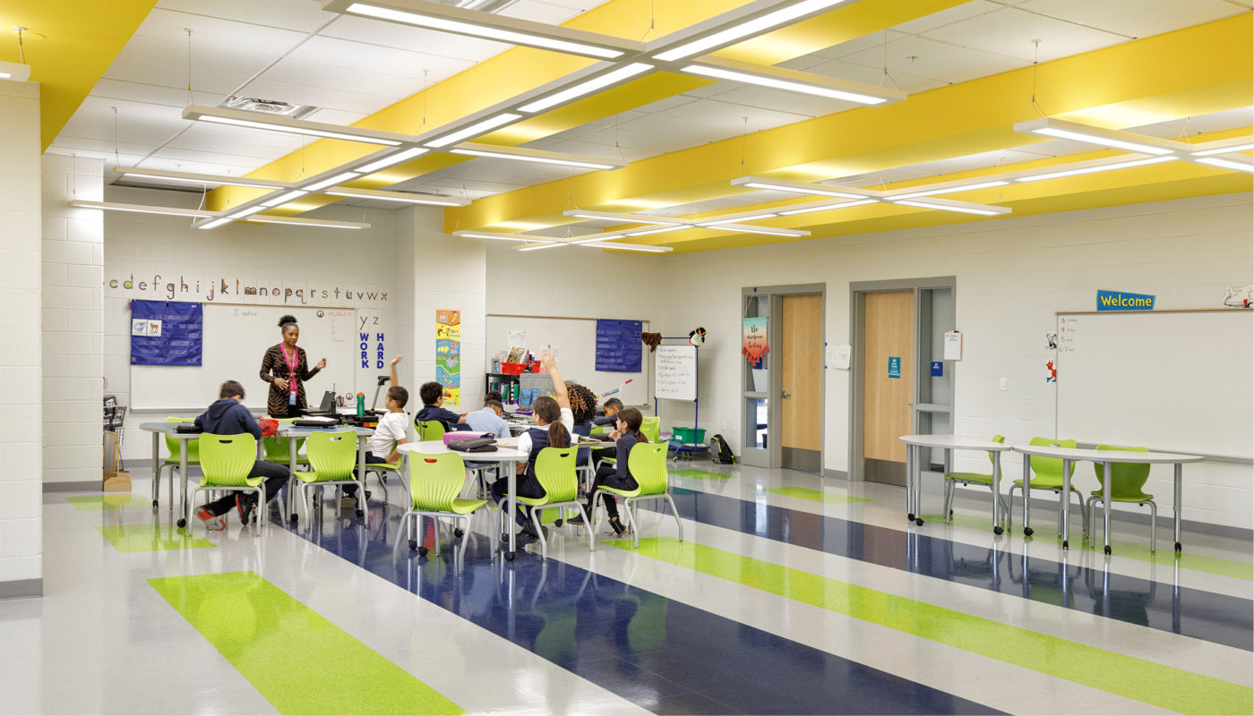 A K-8 classroom with yellow and green walls and chairs, located within Patrick Henry School of Alexandria City Public Schools.