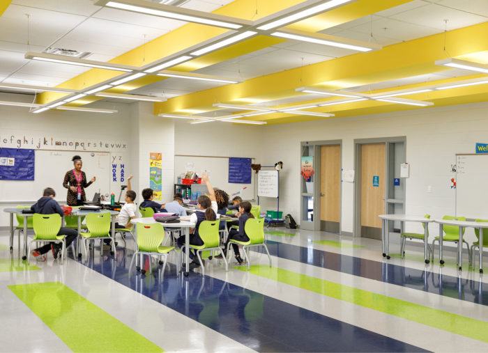 A K-8 classroom with yellow and green walls and chairs, located within Patrick Henry School of Alexandria City Public Schools.