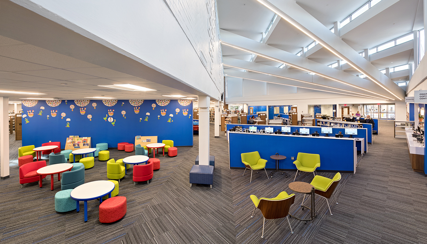 A brightly colored library with tables and chairs.