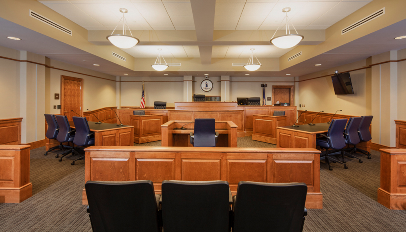 A courtroom with chairs and a clock on the wall.