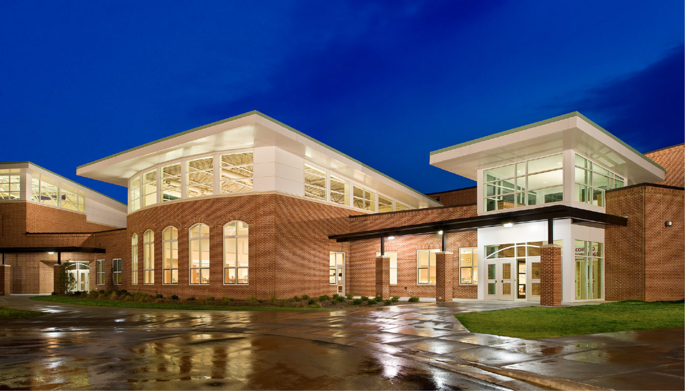 The exterior of Carrboro High School, part of the Chapel Hill-Carrboro City Schools district, lit up at night.