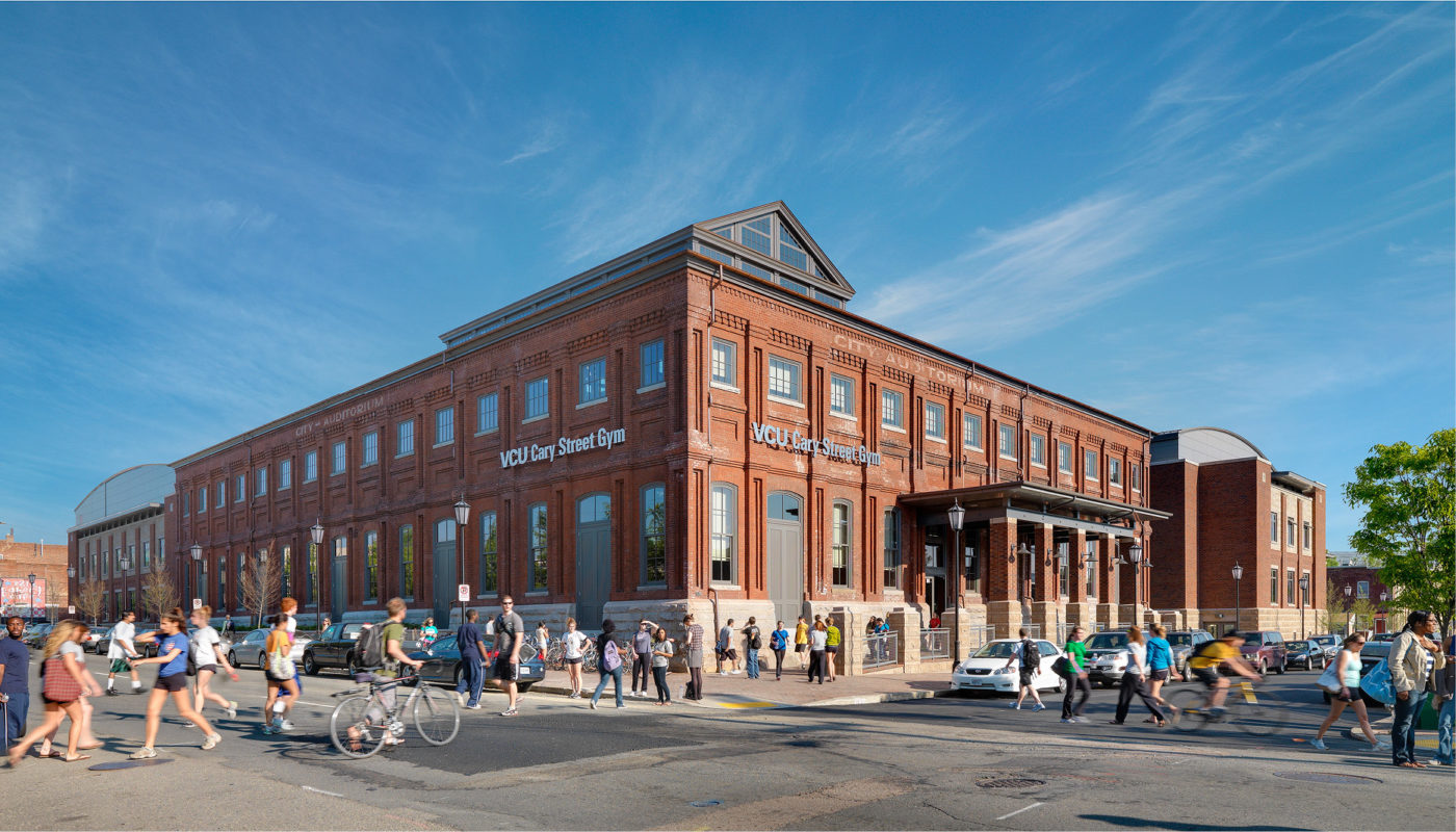 A rendering of a large brick building with people walking in front of it.