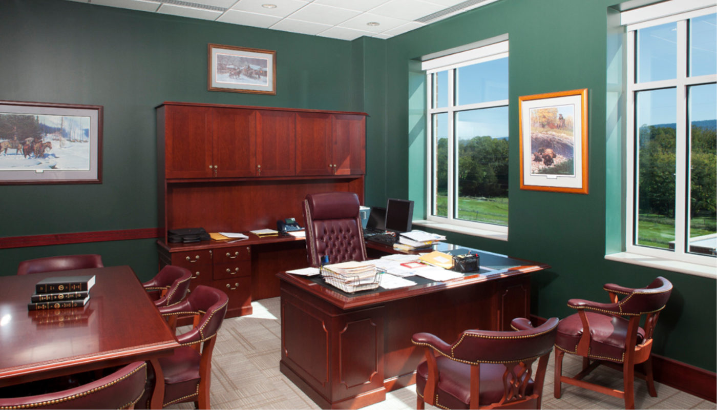 A green office with a desk and chairs.
