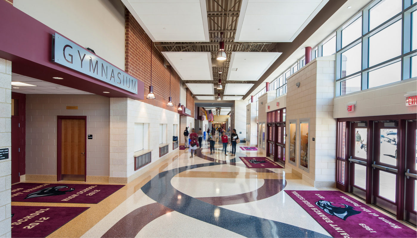 A bustling hallway at Paint Branch High School, part of Montgomery County Public Schools, with students and faculty briskly walking down it.