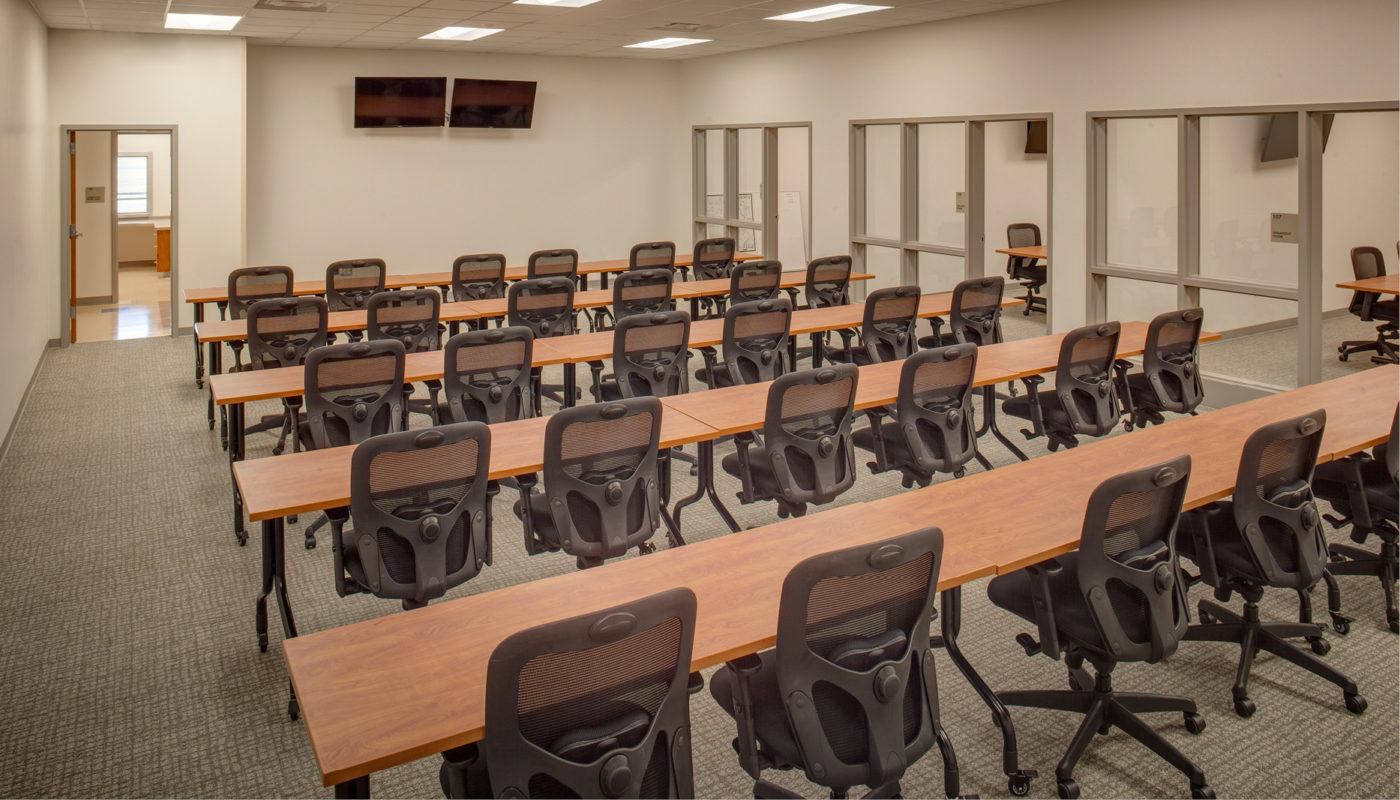 A conference room featuring rows of chairs and a television, designed with an architecture that supports emergency services.