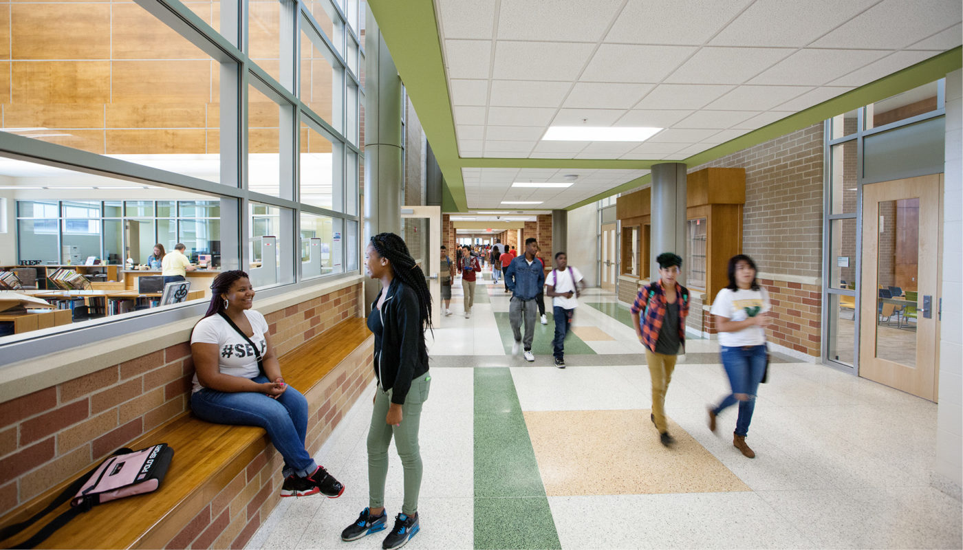 A group of people walking down a hallway at Huguenot High School.