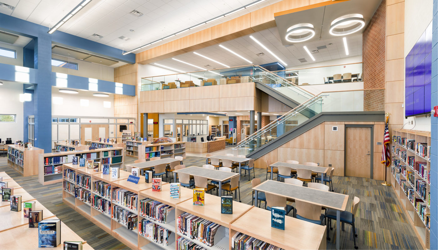The interior of Heritage High School library with bookshelves and stairs, providing a conducive learning environment for students in Lynchburg City Schools.
