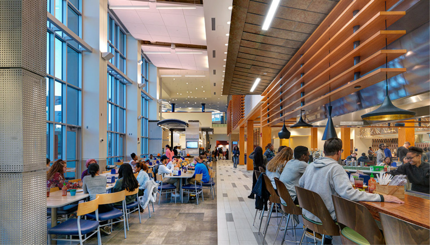 A group of people sitting at tables in a large building.