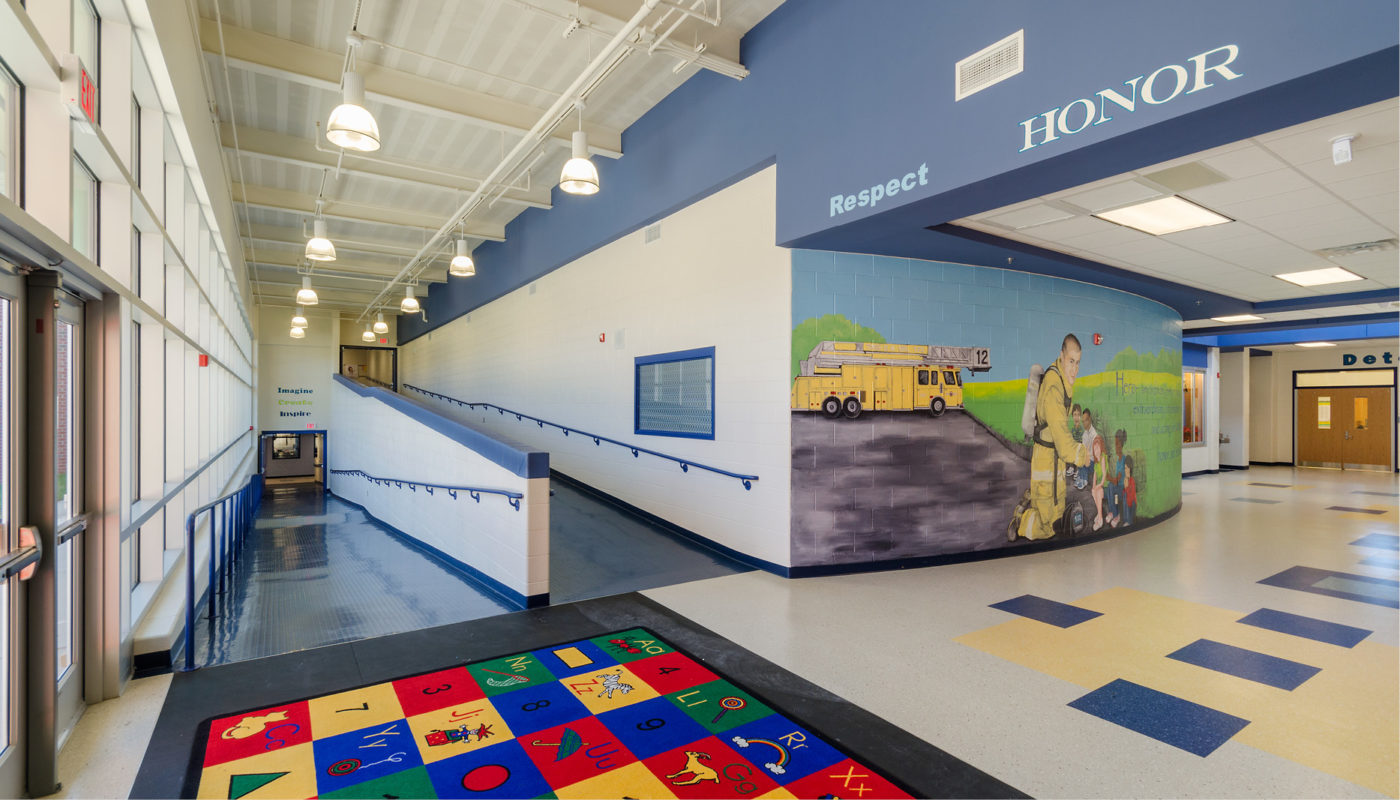 A hallway in a school with a mural on the wall.