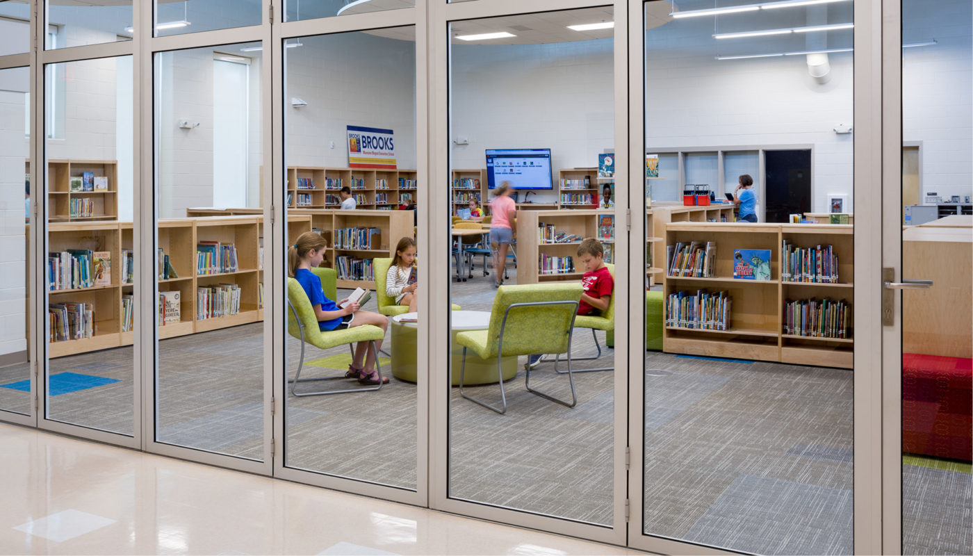 A school library with glass doors and bookshelves.