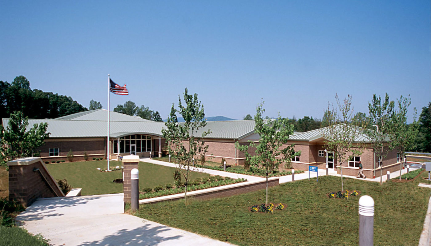 A brick building with a flag on the roof, located at the Blue Ridge Juvenile Detention Center.