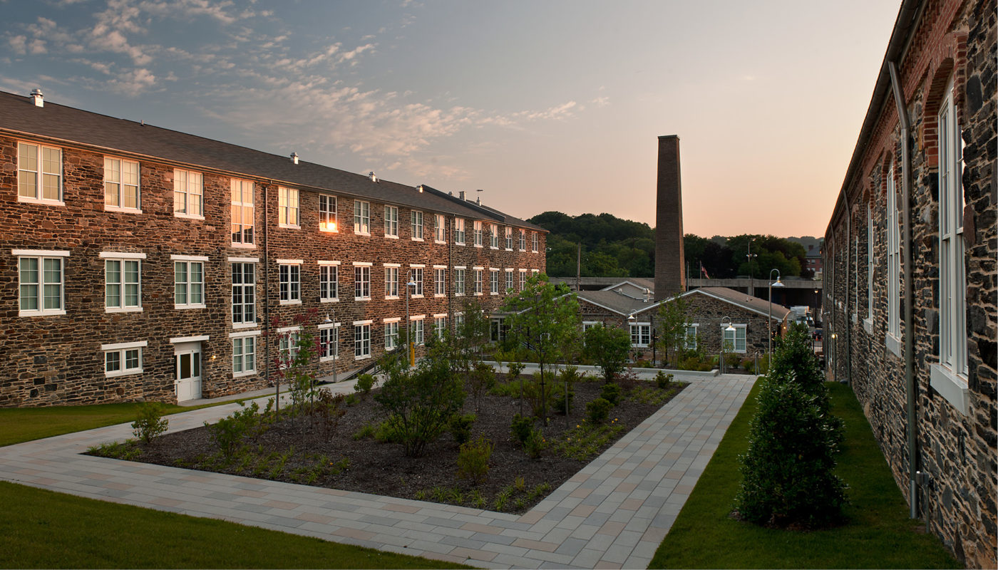 A brick building, known as Union Mill, nestled in the middle of a courtyard.