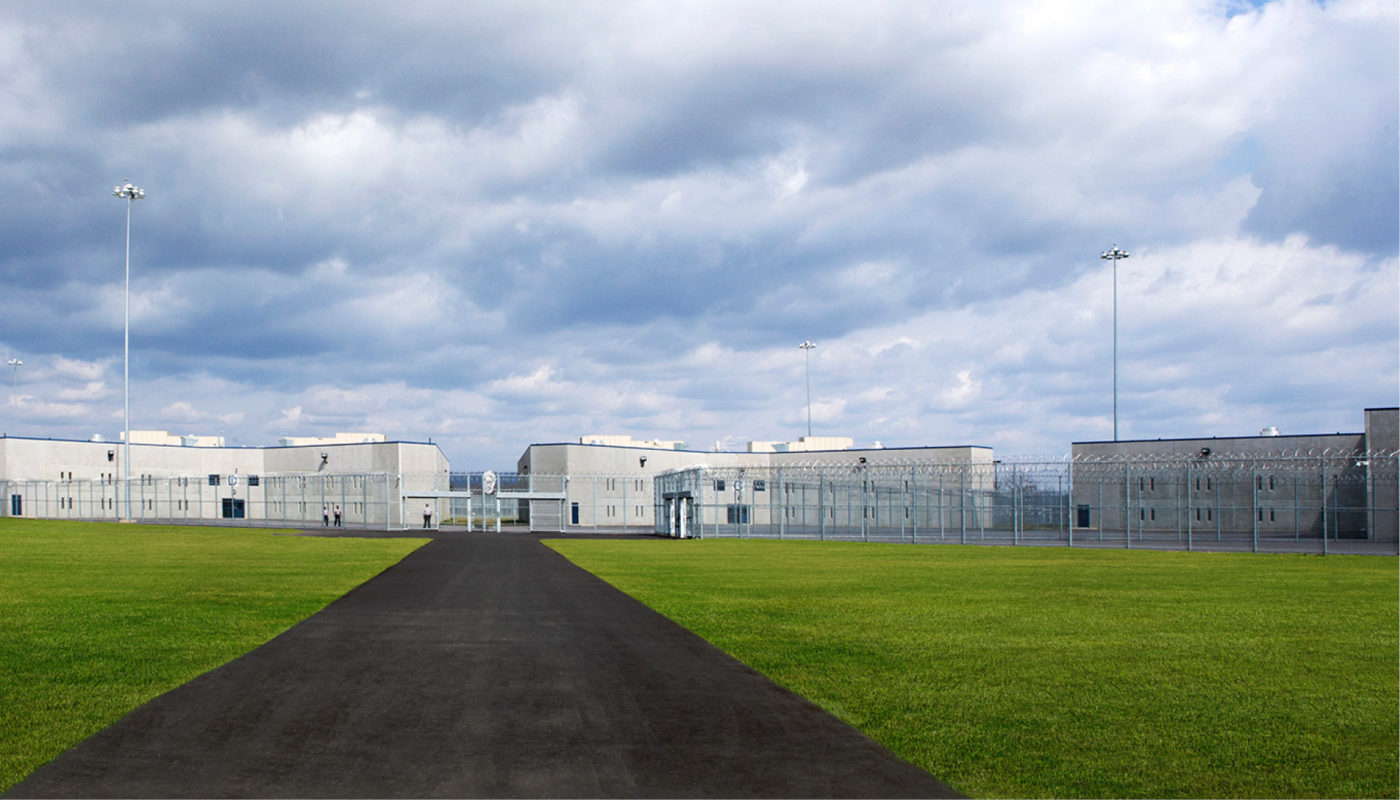 The Benner State Correctional Institution is surrounded by a green, grassy area in front of the building.