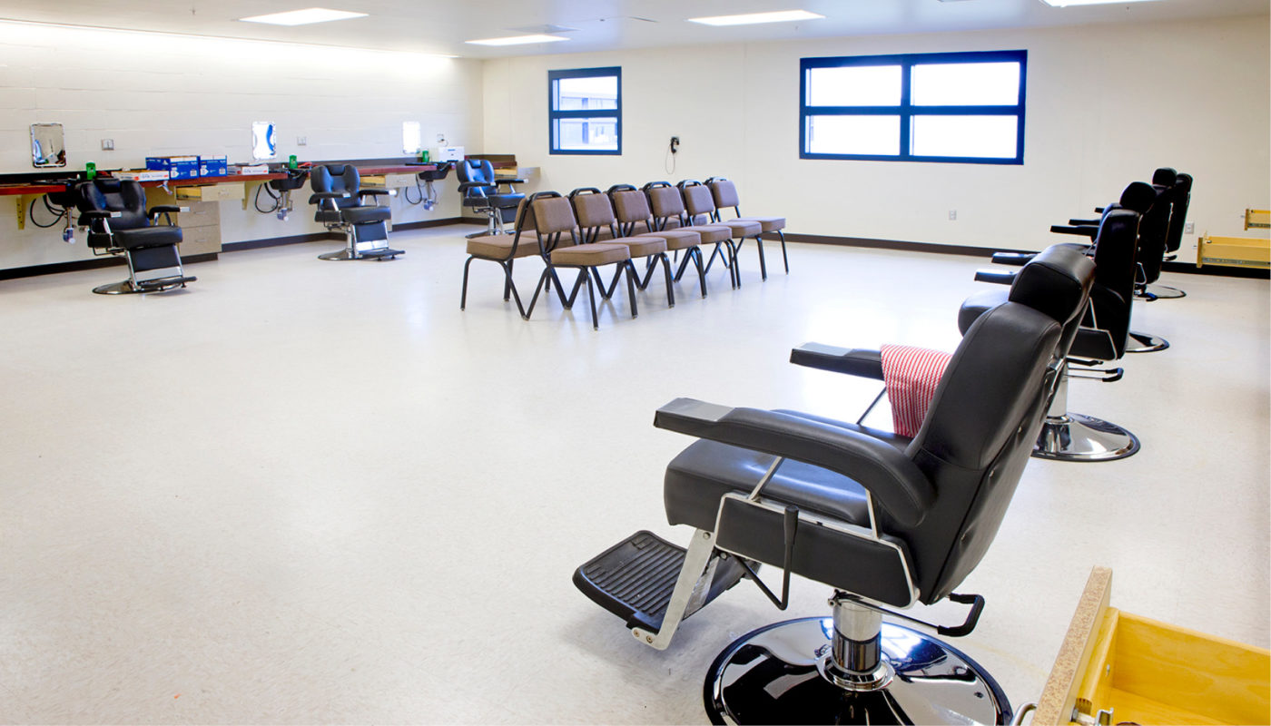 A room at Benner State Correctional Institution filled with barber chairs.