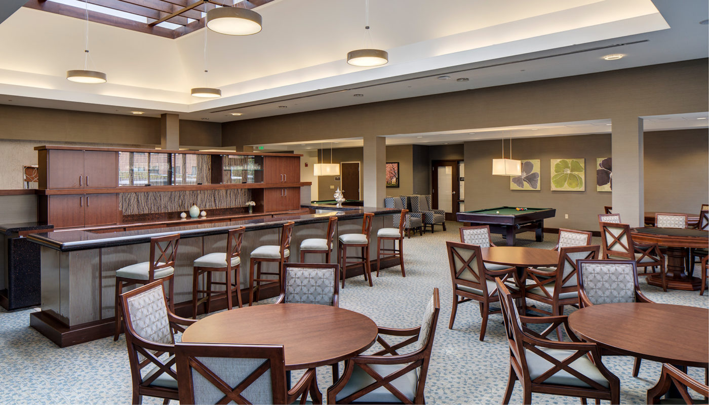 A spacious Community Building featuring a pool table and bar stools, located in Charlestown Square.