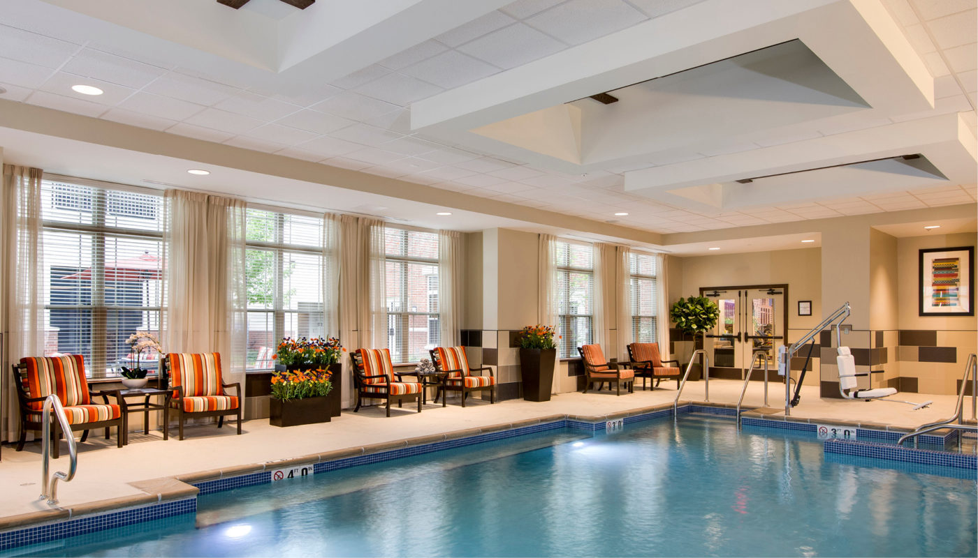 Deer Park - an indoor swimming pool with lounge chairs and windows.