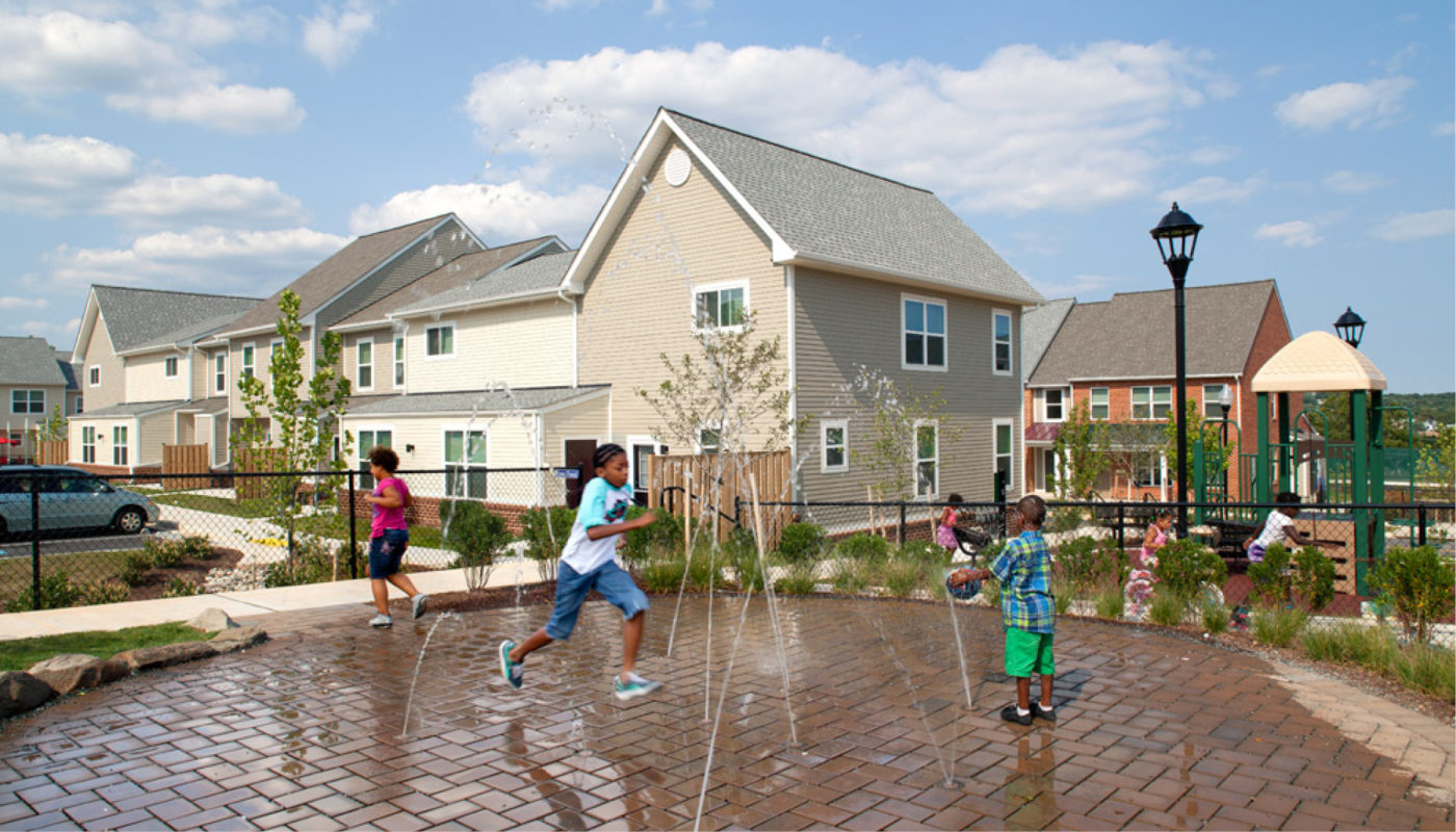 A group of children playing in Key's Pointe water fountain.