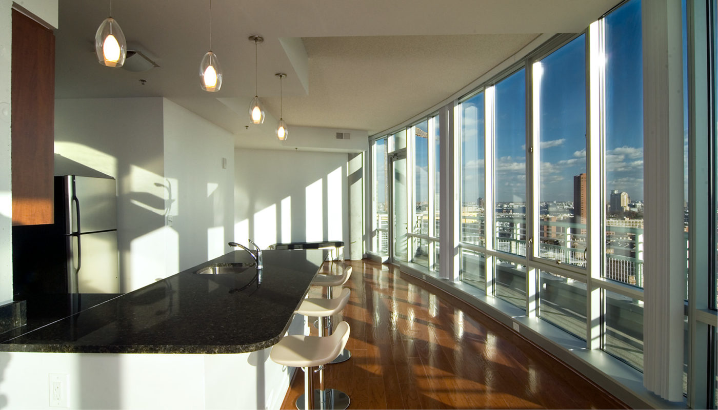 A kitchen with large windows offering a breathtaking view of the city's zenith.