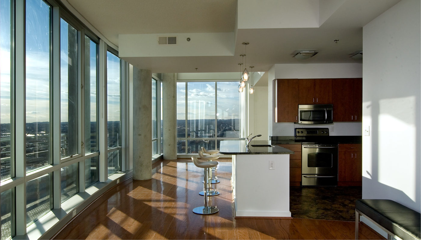 A kitchen with large windows offering a stunning zenith view of the city.