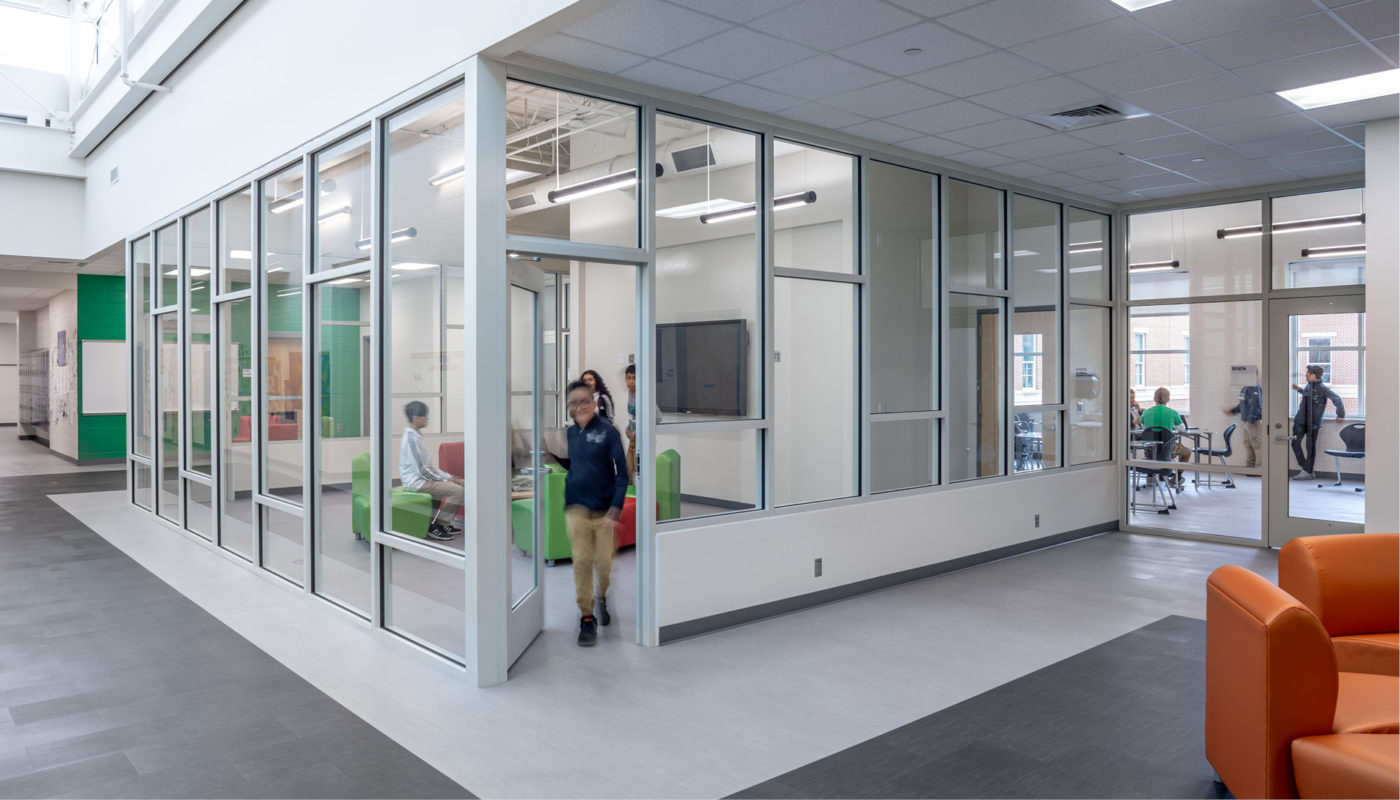 A classroom in Kannapolis Middle School with glass walls and a person standing in the doorway.