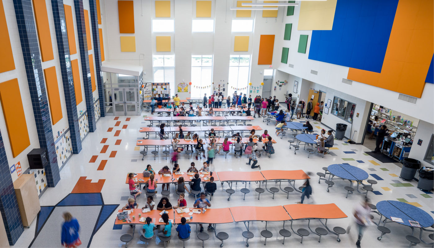 Royal Oaks Elementary School is a large school building with many tables and chairs.