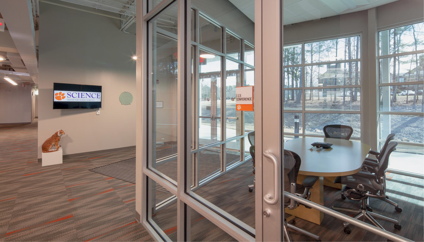 The Self Regional Hall at Clemson University is a modern conference room with glass walls and a state-of-the-art television.