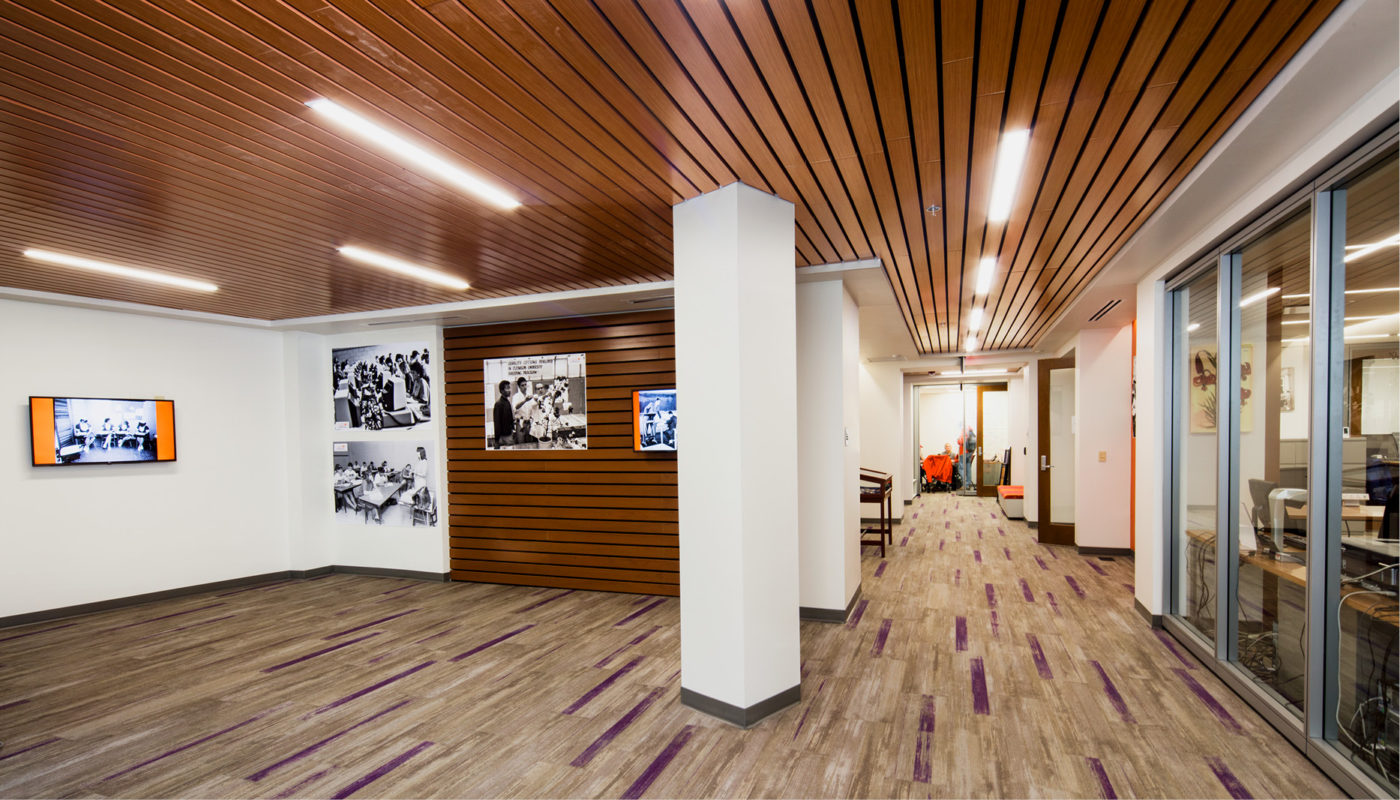 The Class of 1944 Visitors Center at Clemson University features an office with a wooden ceiling and pictures on the wall.