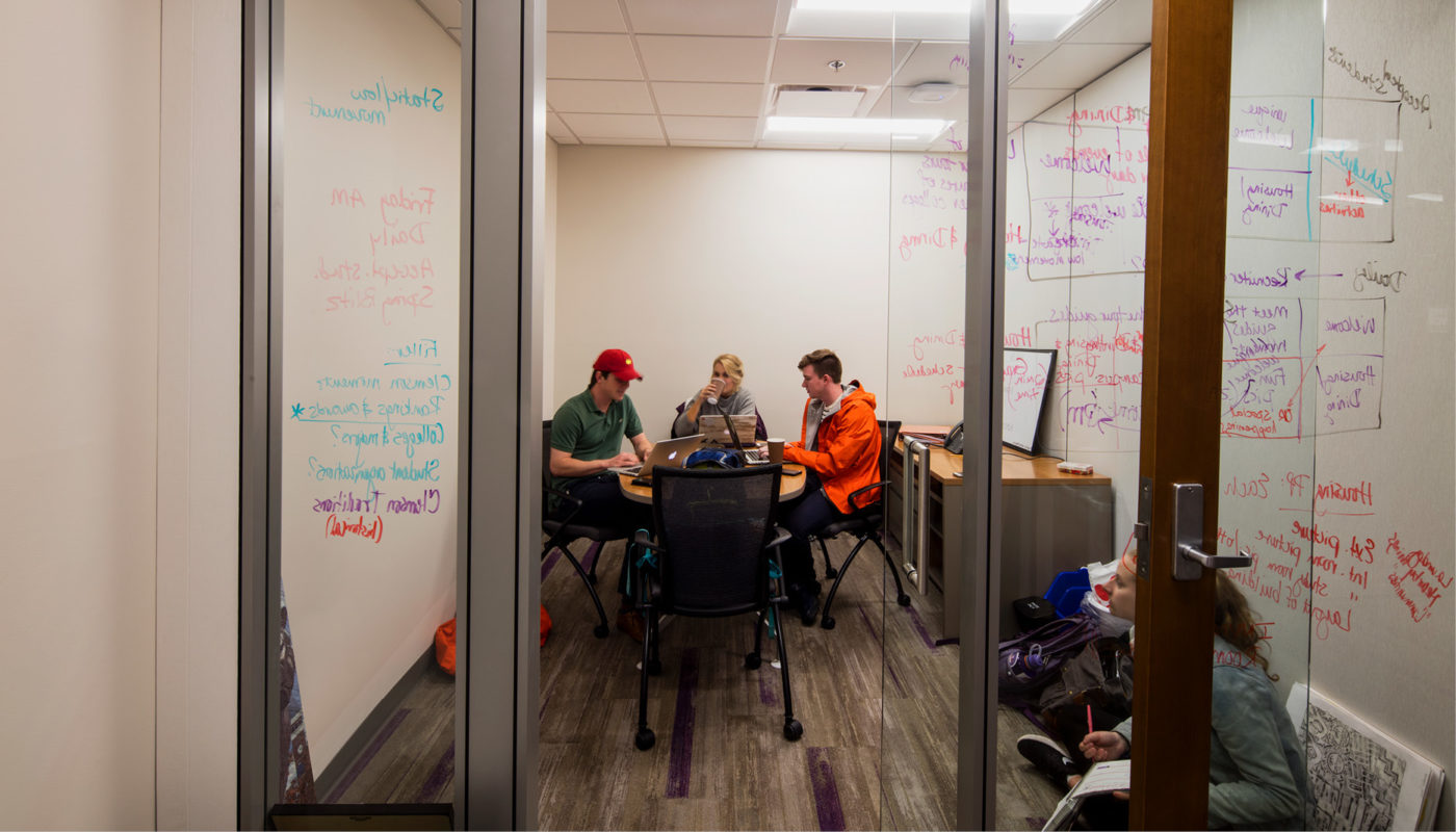 A group of people sitting around a table in the Clemson University office.