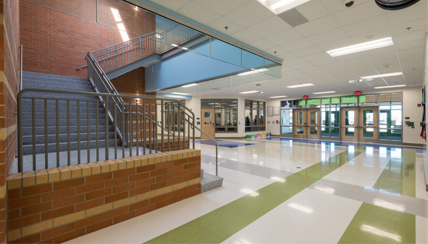 A hallway with stairs and a green floor at Goshen Post Elementary School in Loudoun County Public Schools.