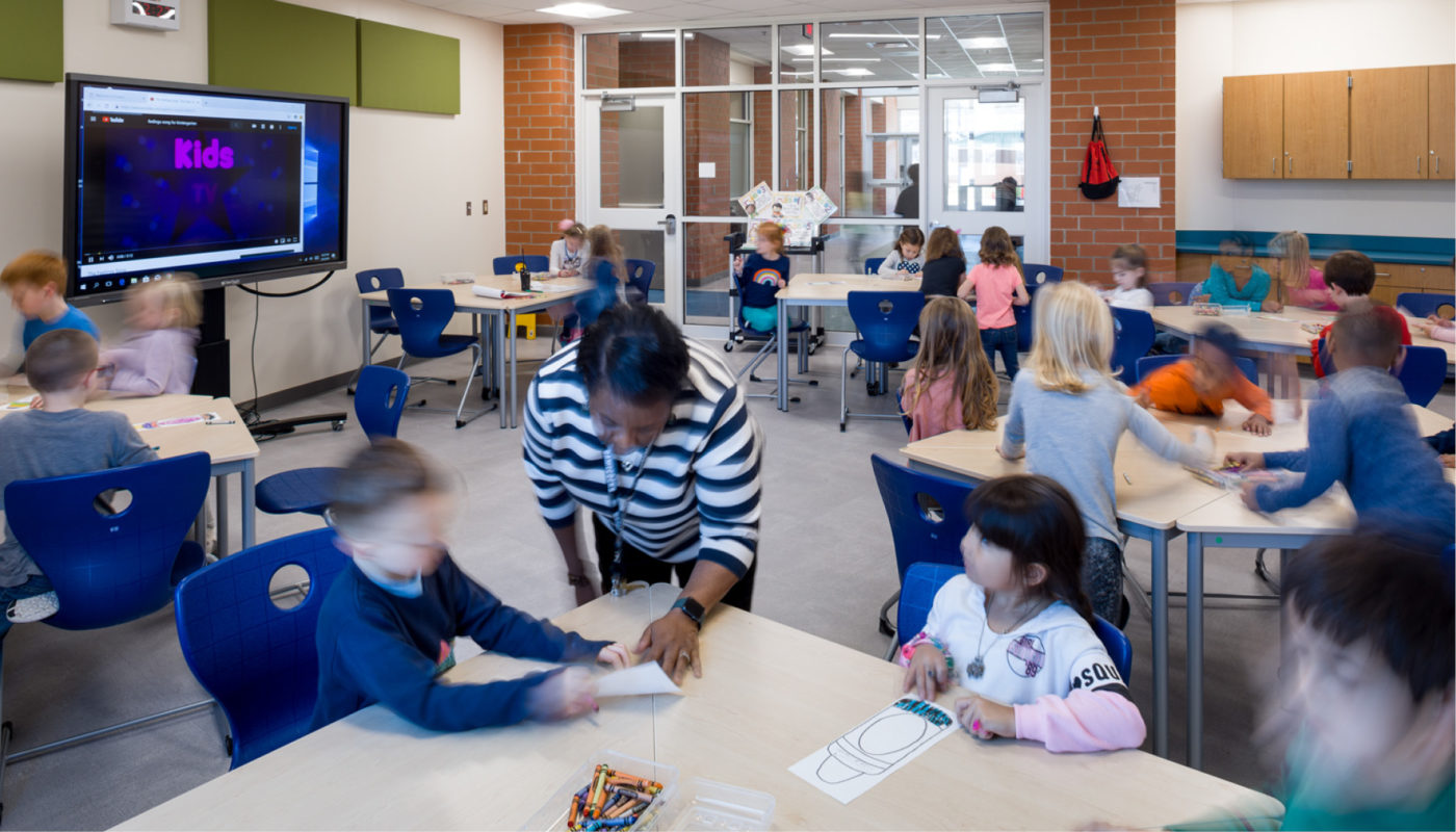 At Cherry Park Elementary School, children are engaged in learning as they sit at tables and watch a TV, creating an interactive and educational experience within Rock Hill Schools.