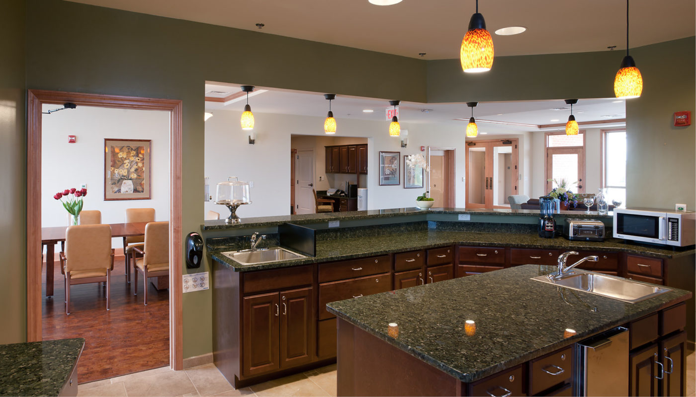 A Stadium Place kitchen with green house counter tops and a sink.