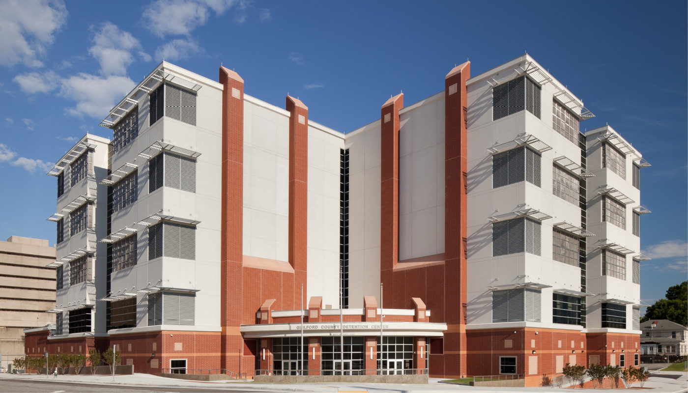 The Guilford County Detention Center is a large building with many windows and balconies.