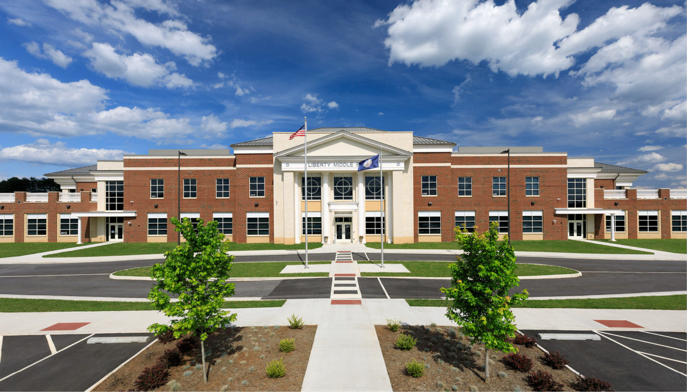An image of Liberty Middle School, a brick building with trees and a blue sky.