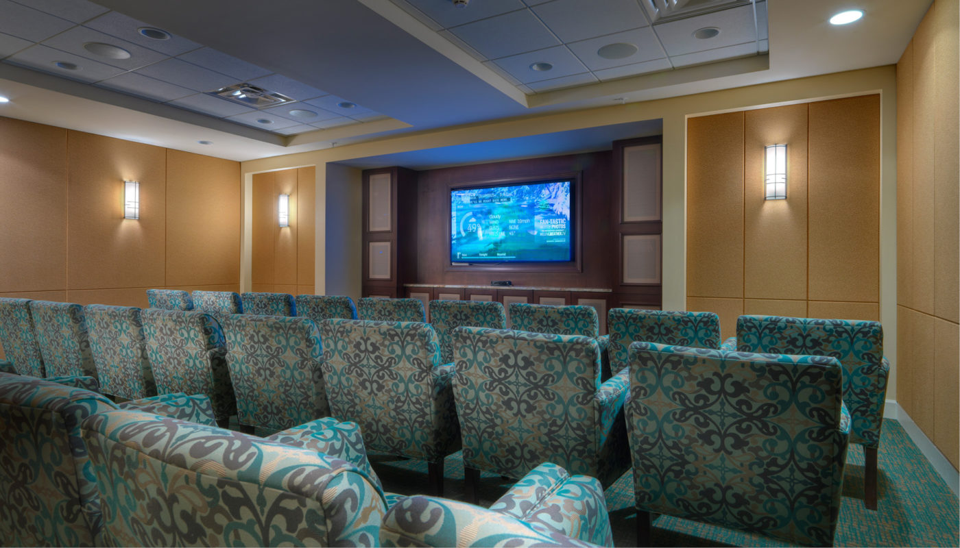 A Senior Star theater room in Dublin with blue chairs and a tv.