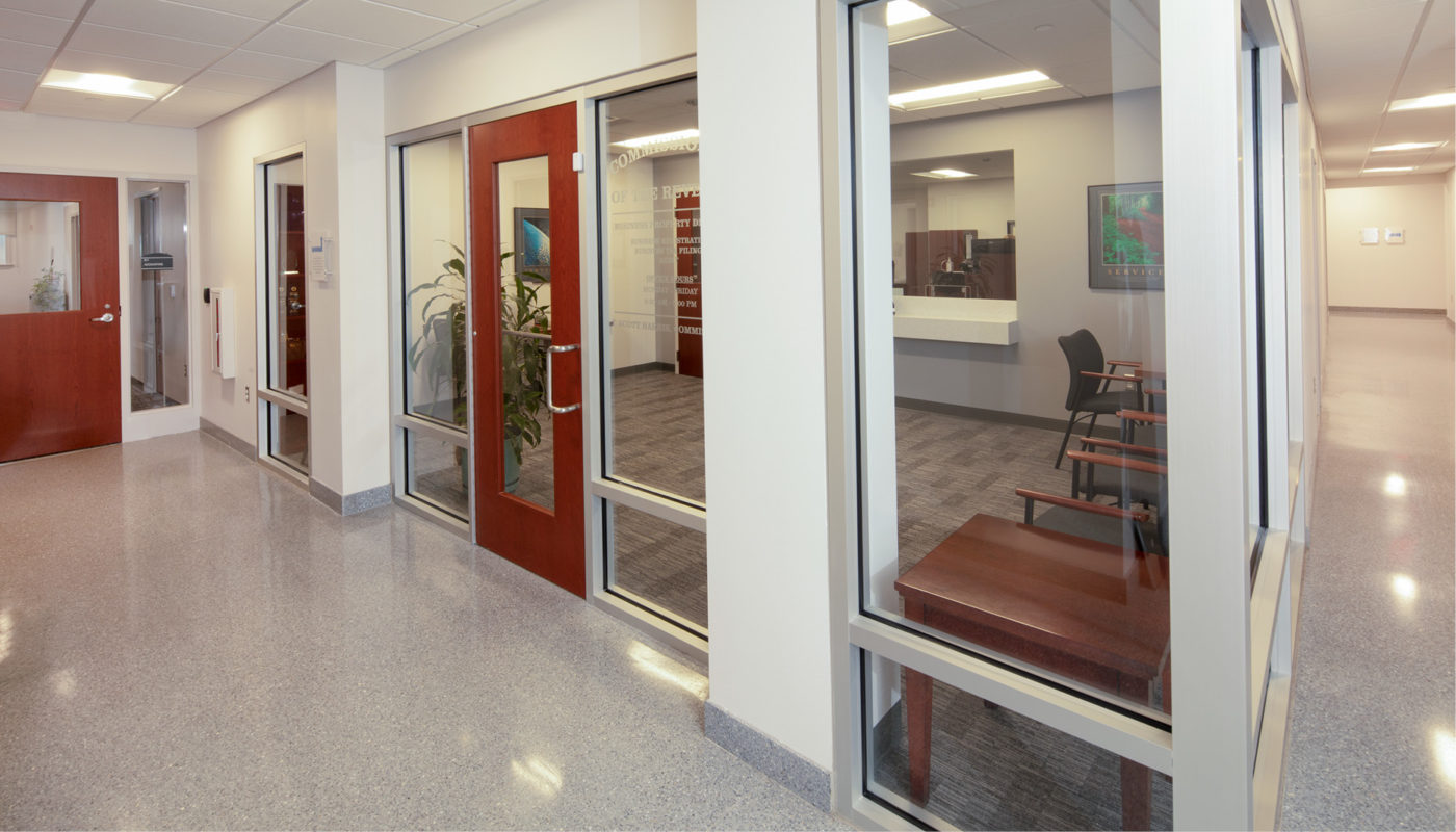 The Chenault-Weems Building features a modern hallway in a medical office, lined with sleek glass doors.