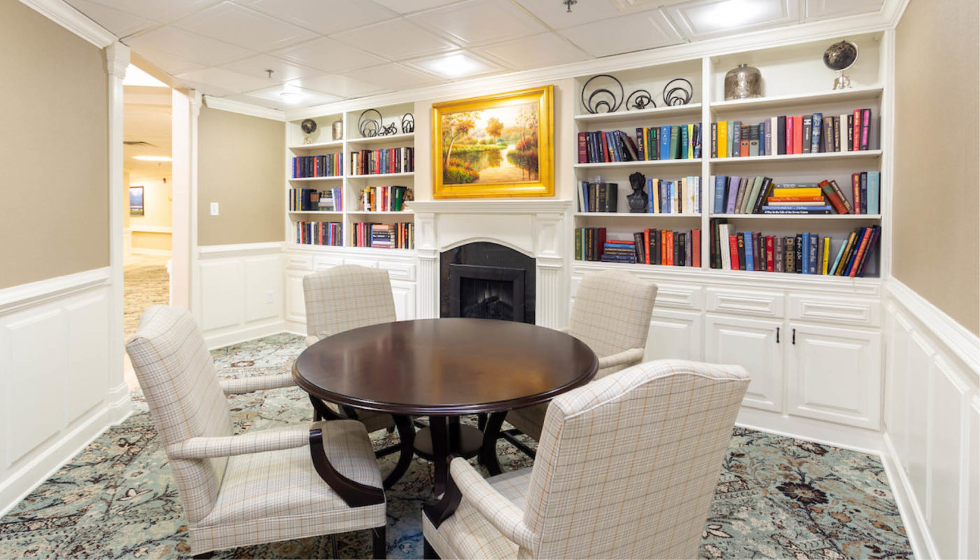 An Independent Living dining room with a fireplace and bookshelves.
