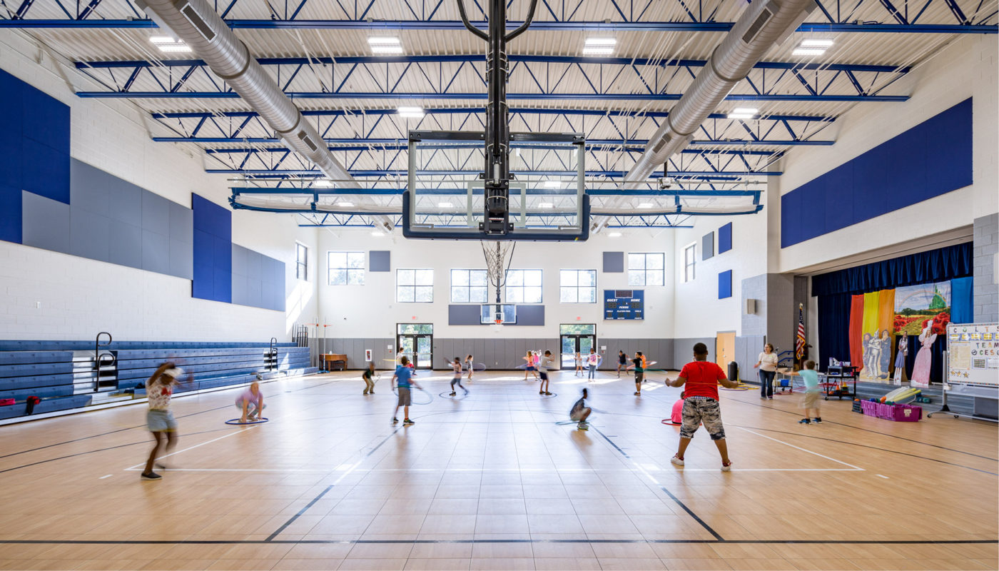 A group of children from Camden Elementary School playing basketball in a gymnasium.
