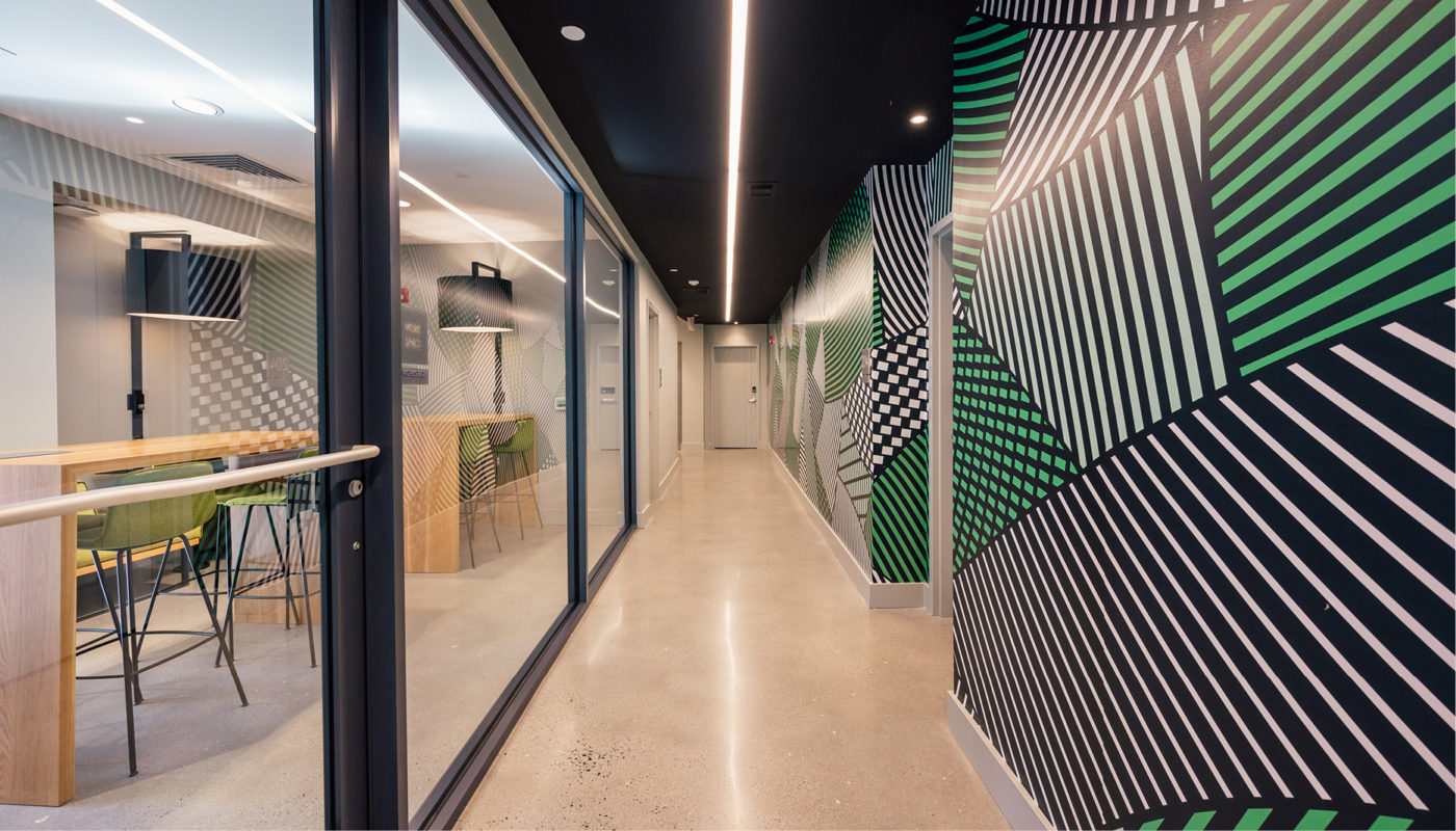 A hallway in an office with green and black stripes is a part of the wheelhouse.
