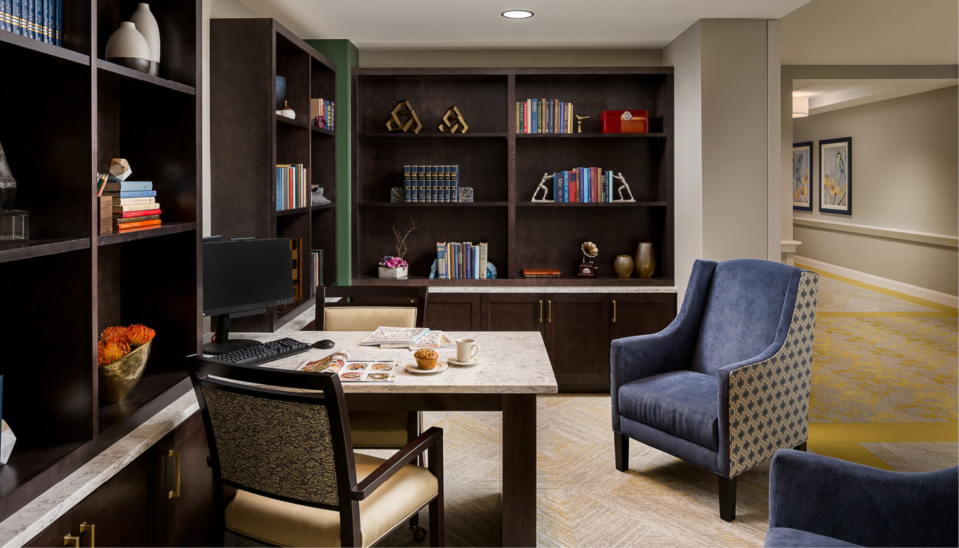 Atria Glenview is a home office equipped with a desk, chair, and bookshelves.